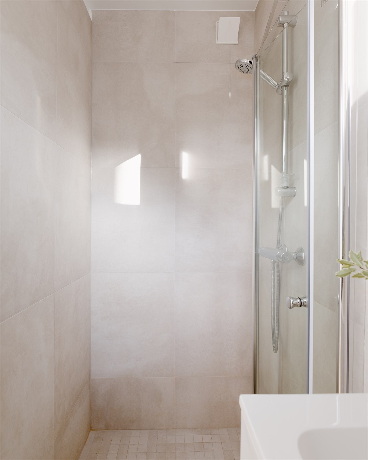 Badet er innredet med servant, dusjhjørne med dusj rett på flis. Galleribilde