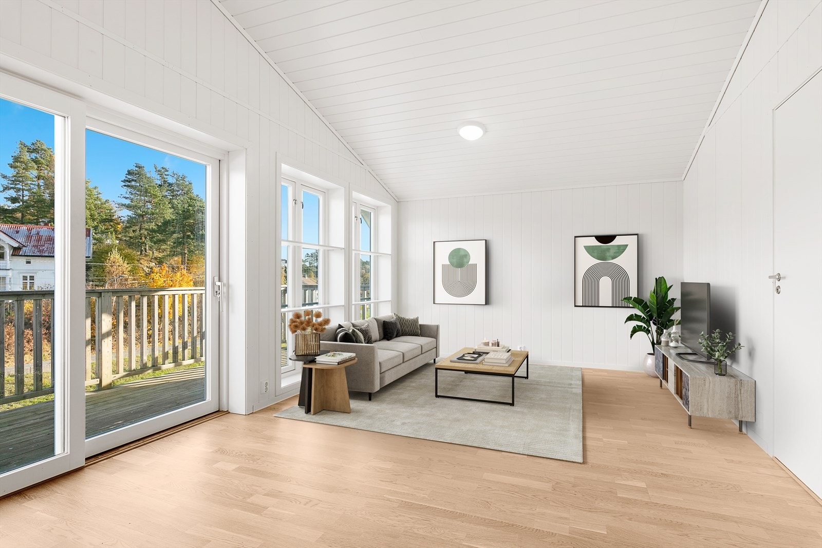 Flott stue-/spisestue med store vindusflater, gode takhøyde og skyvedør ut til verandaen. Bildet er digitalt stylet Galleribilde