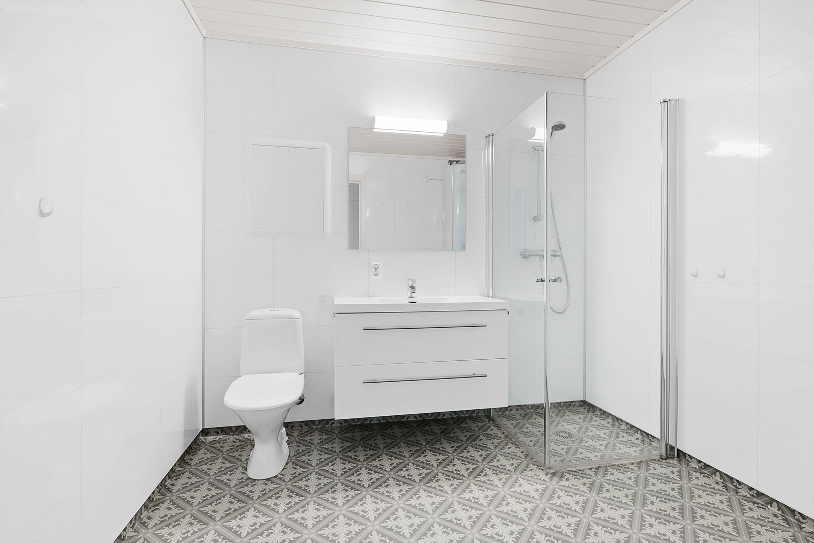 Stort og pent bad med wc, servant i seksjon og dusjhjørne med glassvegger. Opplegg til vaskemaskin. Det er varmekabler i gulv. Galleribilde