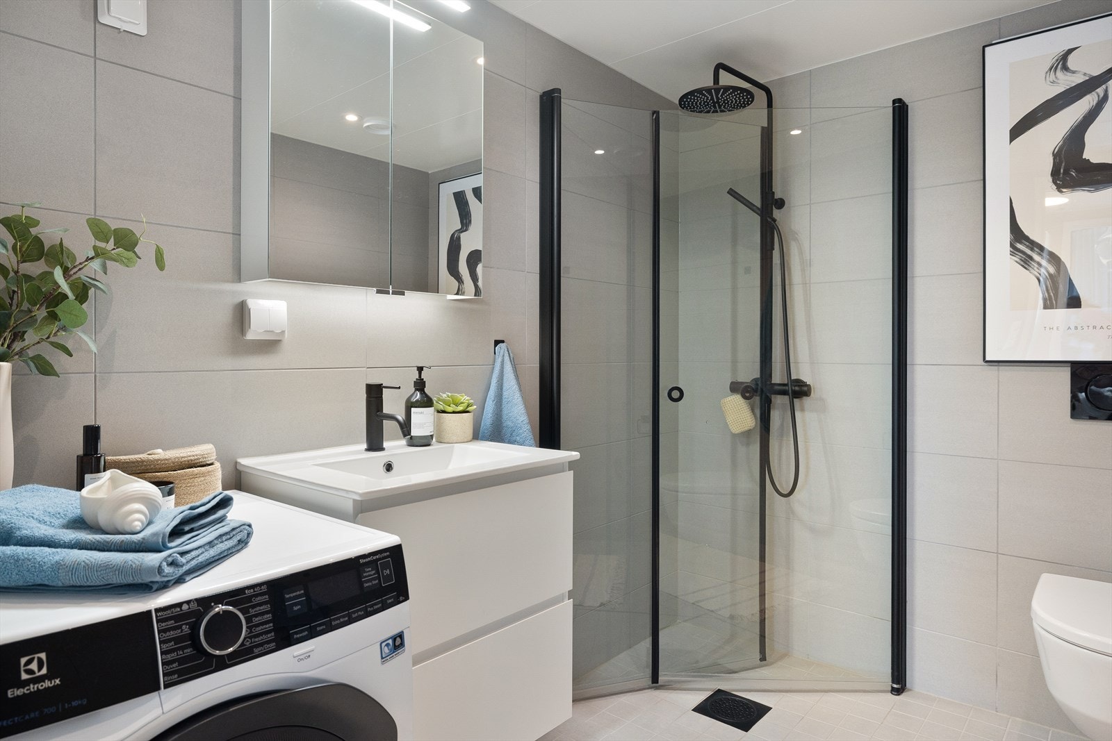 Innredningen består av nedfelt servant med underskap, speilskap, vegghengt toalett og dusjhjørnet med svingbare dører Galleribilde