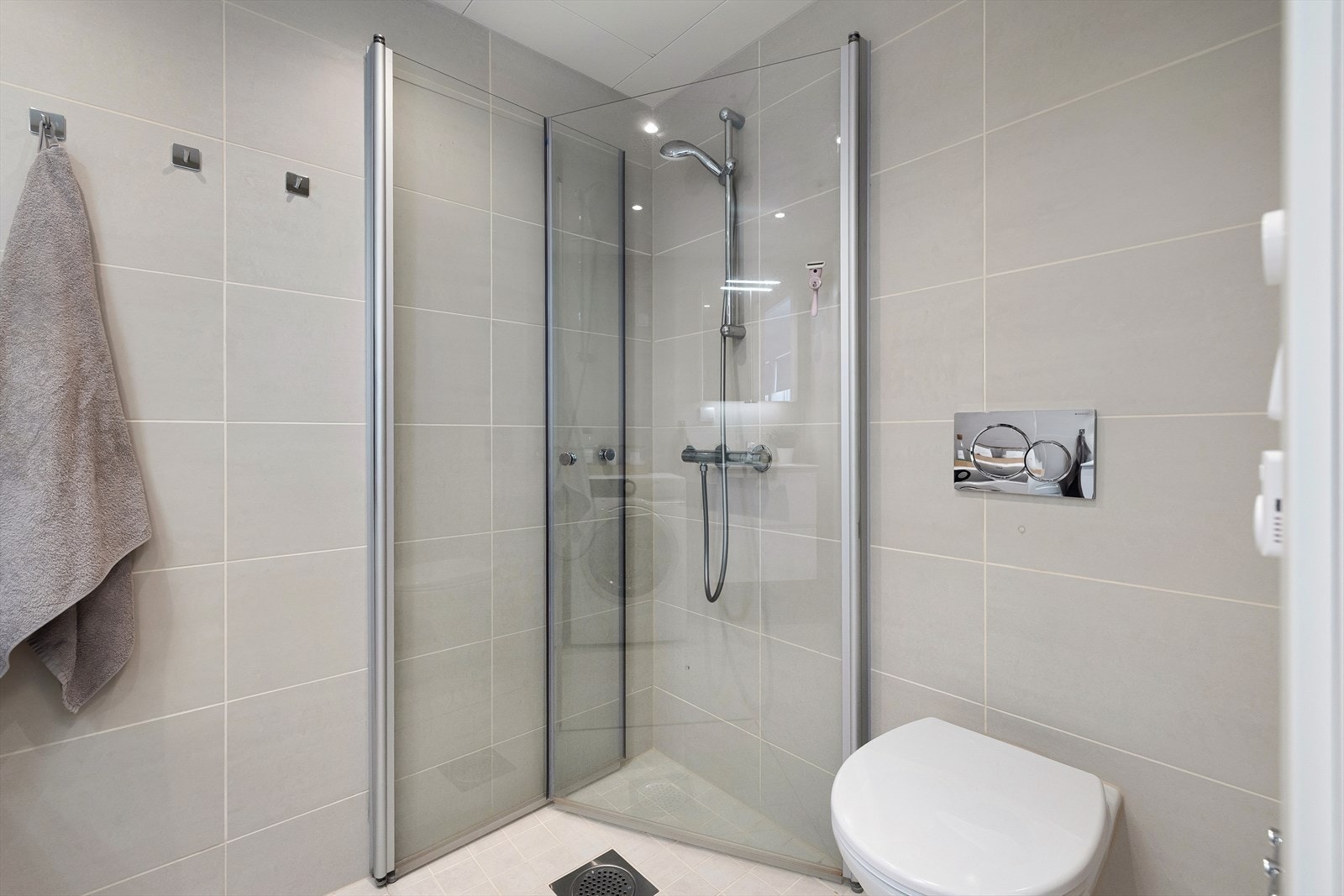 Innredningen består av servant med underskap, speilskap, vegghengt toalett og dusjhjørne med svingbare dører Galleribilde