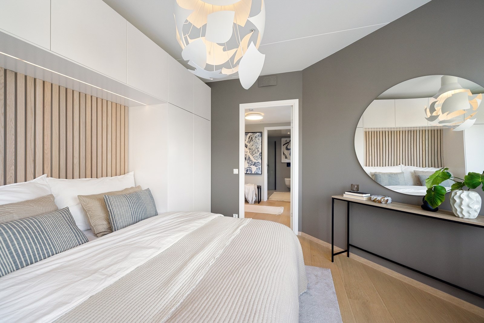 Det er godt med skapplass i en plassbygd garderobeløsning rundt og over sengen Galleribilde