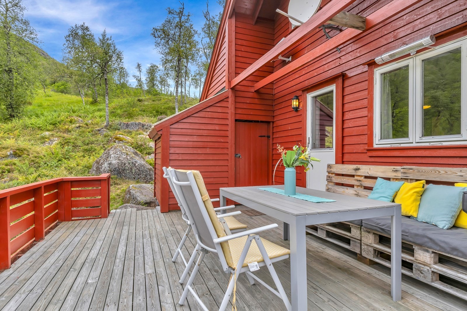 På altanen finner du en romslig bod, ideell for oppbevaring av utemøbler, redningsvester og annet utstyr man ønsker å ha lett tilgjengelig på hytta. Tomten strekker seg opp i fjellet. Galleribilde