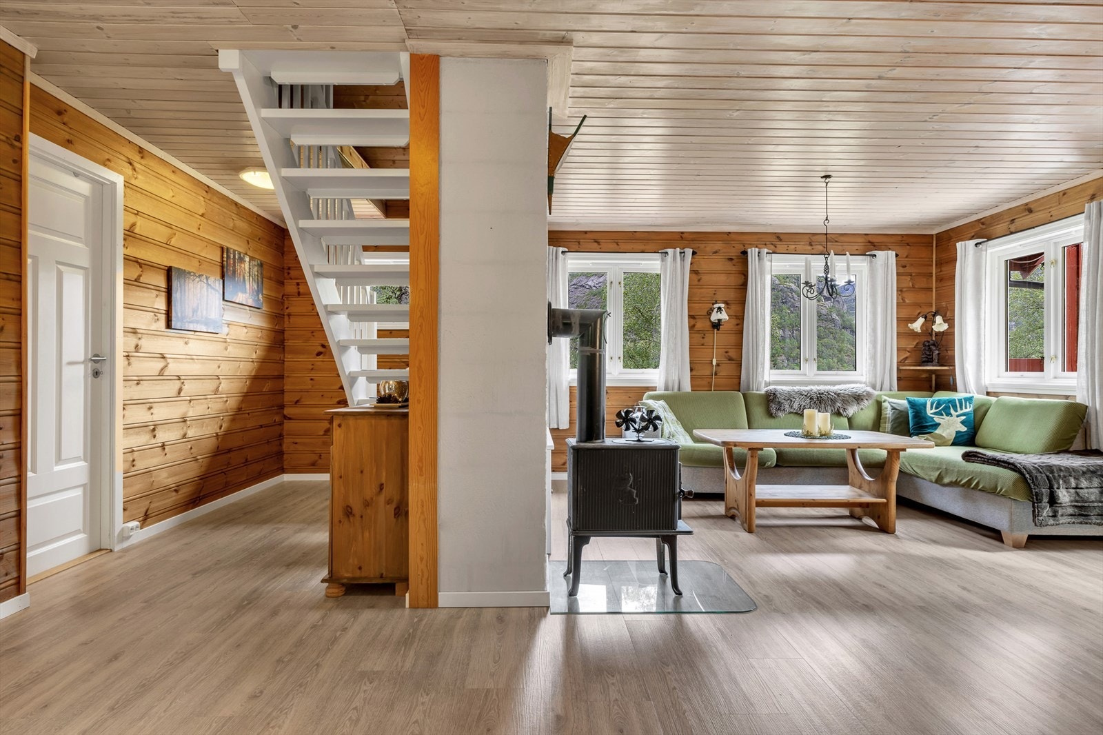 Bilde tatt fra kjøkkenet med utsikt mot stue, soverom og trappen opp til loftetasjen. Galleribilde