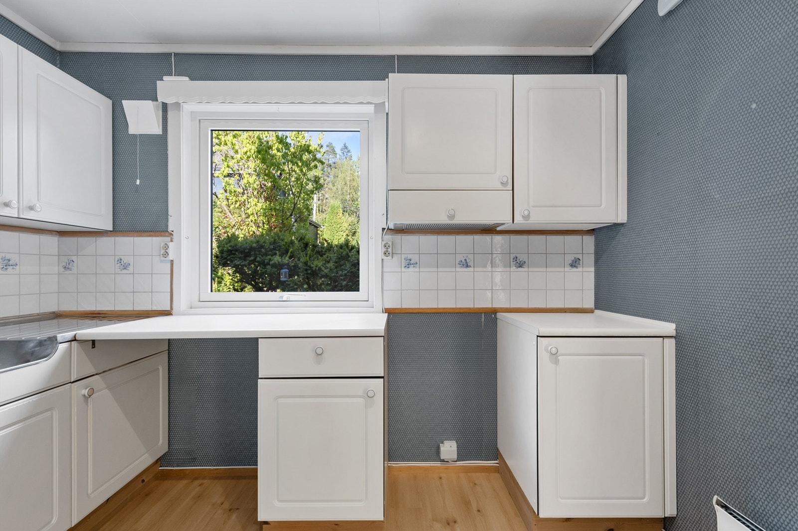 Kjøkkeninnredningen er med glatte fronter og laminat benkeplate med nedfelt vask. Avtrekk over kokeplass. Galleribilde