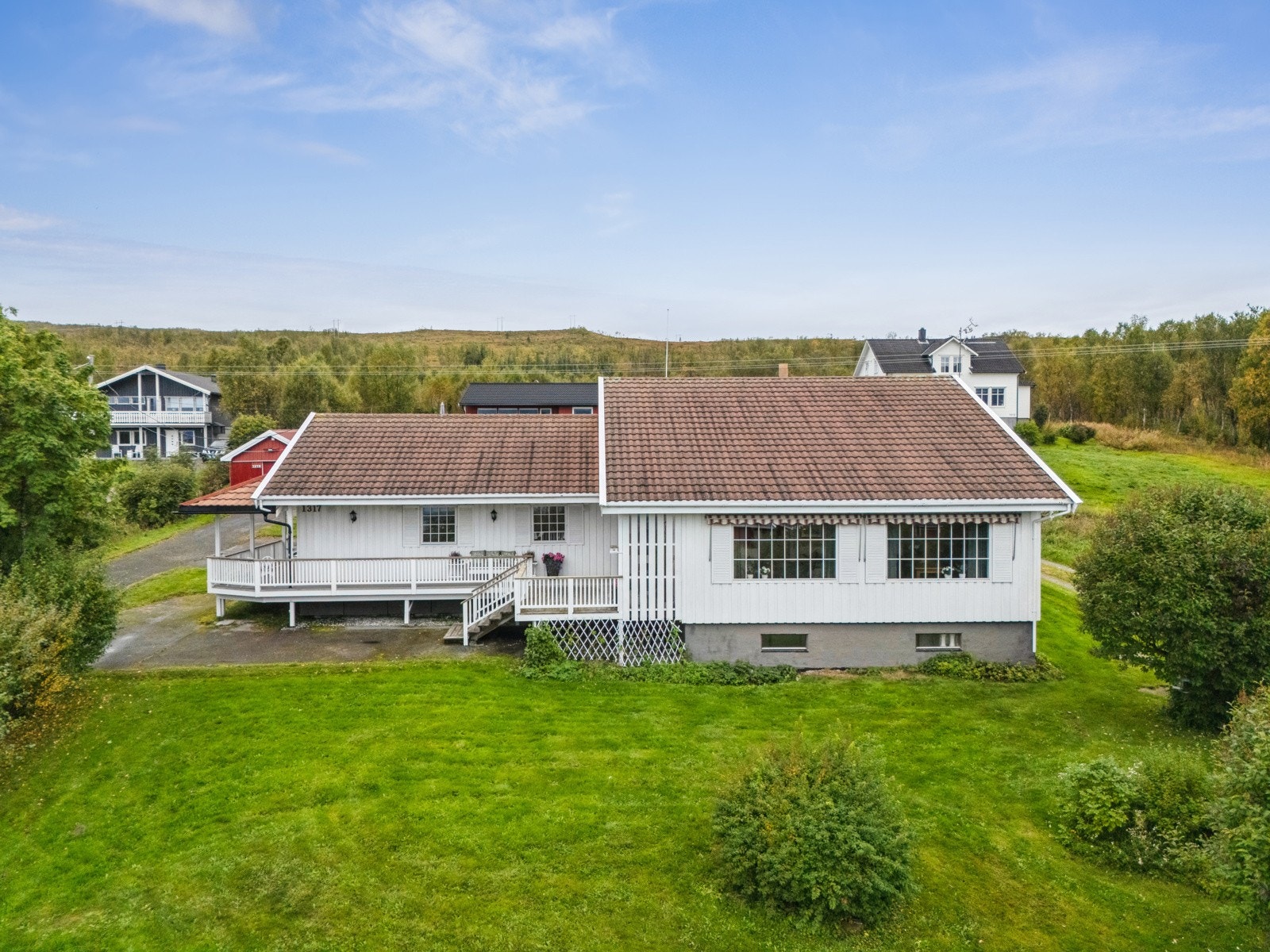 Fra stua har du utgang til en trivelig veranda som strekker seg langs boligen.