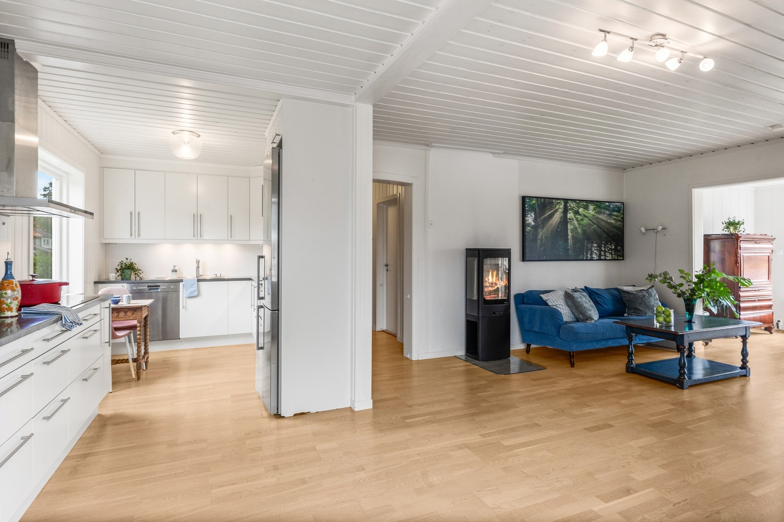 Stuen ligger i åpen løsning med kjøkkenet og har et moderne preg med lyse overflater. Galleribilde