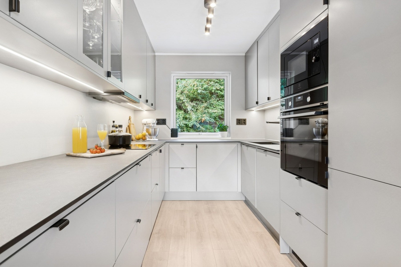 Kjøkkenet har alle hvitevarer integrert, med benkeplate i laminat, underlimt vask og LED-stripe under overskap. Galleribilde