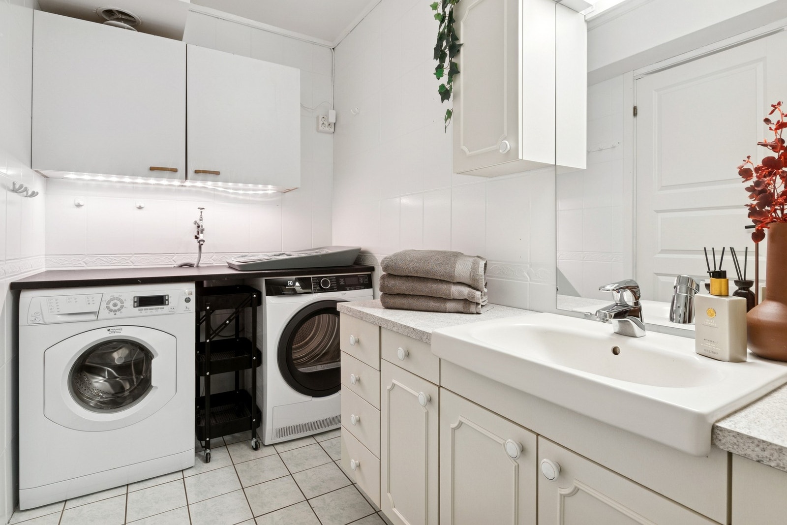 Praktisk seksjon på badet med plass til vaskemaskin, tørketrommel - og oppbevaring i overskap. Galleribilde