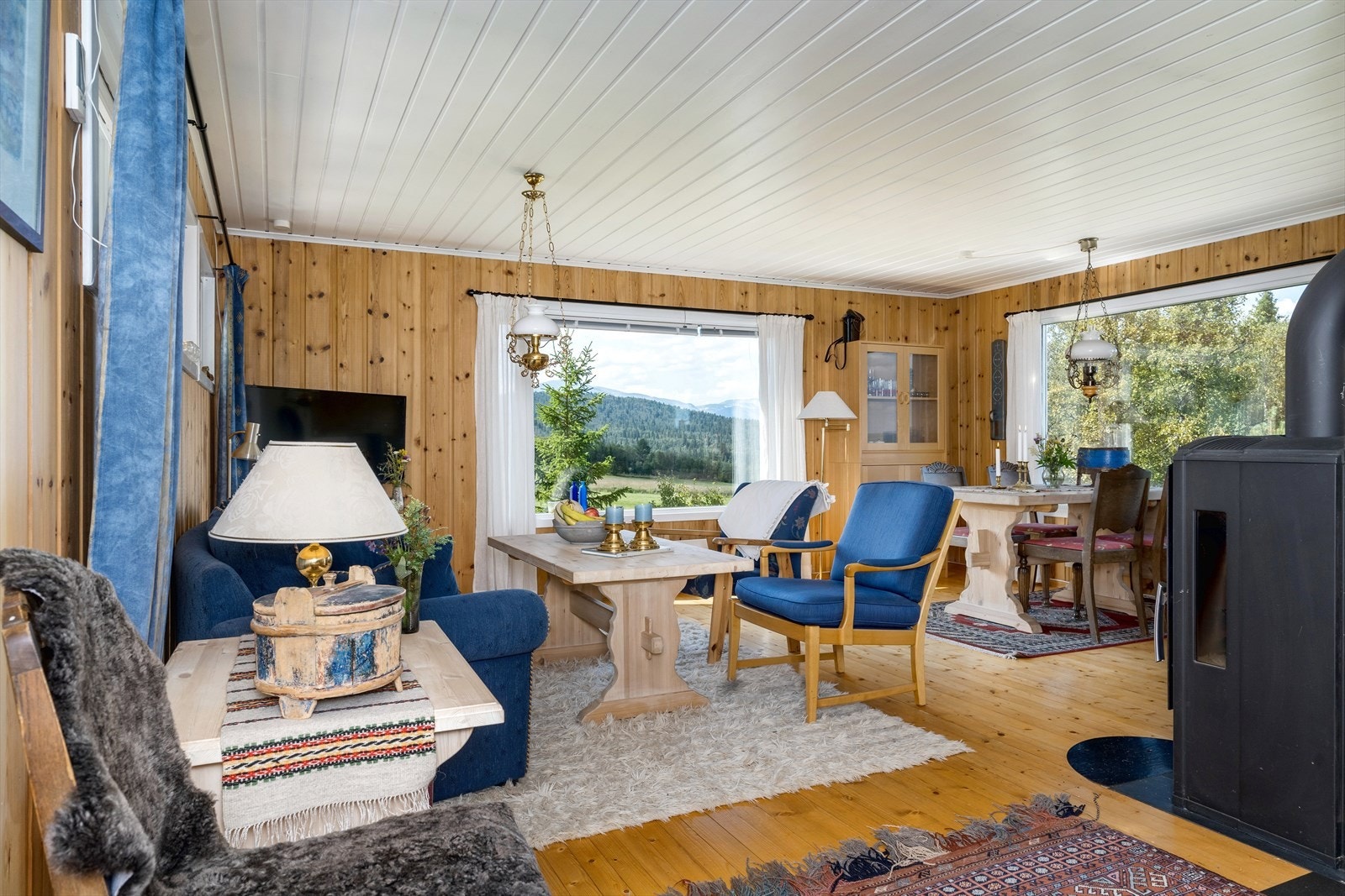 Lys og romslig stue med store vinduer som gir flott utsikt til vakker natur. Perfekt for avslapning og hygge. Galleribilde