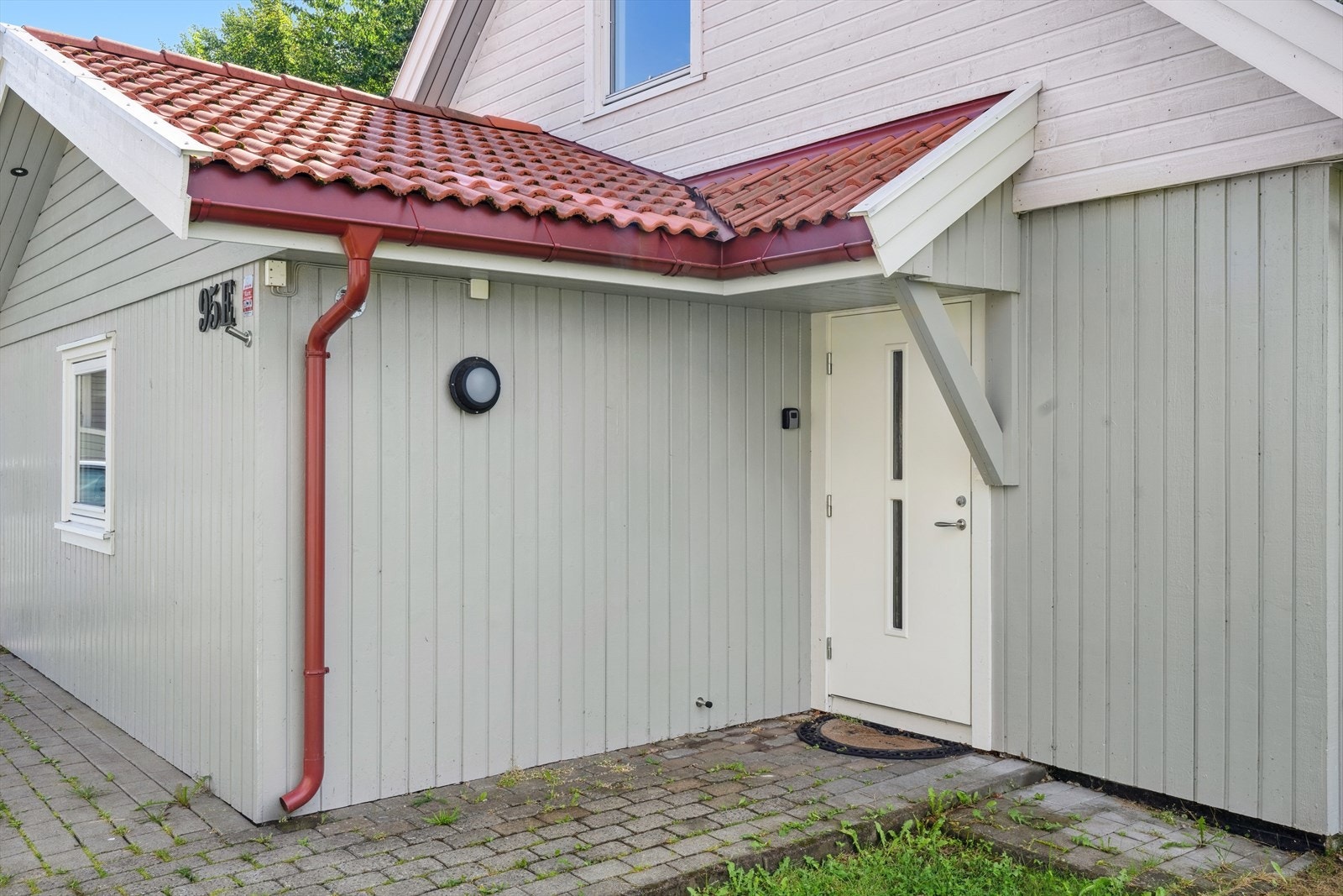 Tomtem er opparbeidet med asfaltert innkjørsel med parkeringsplasser, pene uteplasser med terrasser og gressplen. Galleribilde