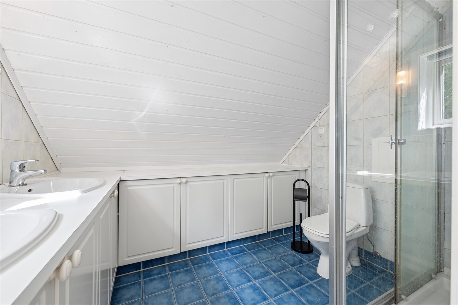 Rommet er innredet med dusjhjørne med glassvegger, toalett og dobbel servantløsning. Galleribilde