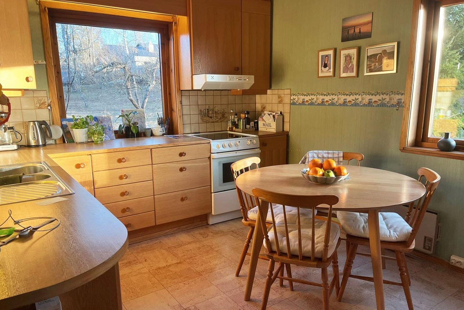 Romslig kjøkken med store vinduer ut mot den usjenerte hagen. Galleribilde