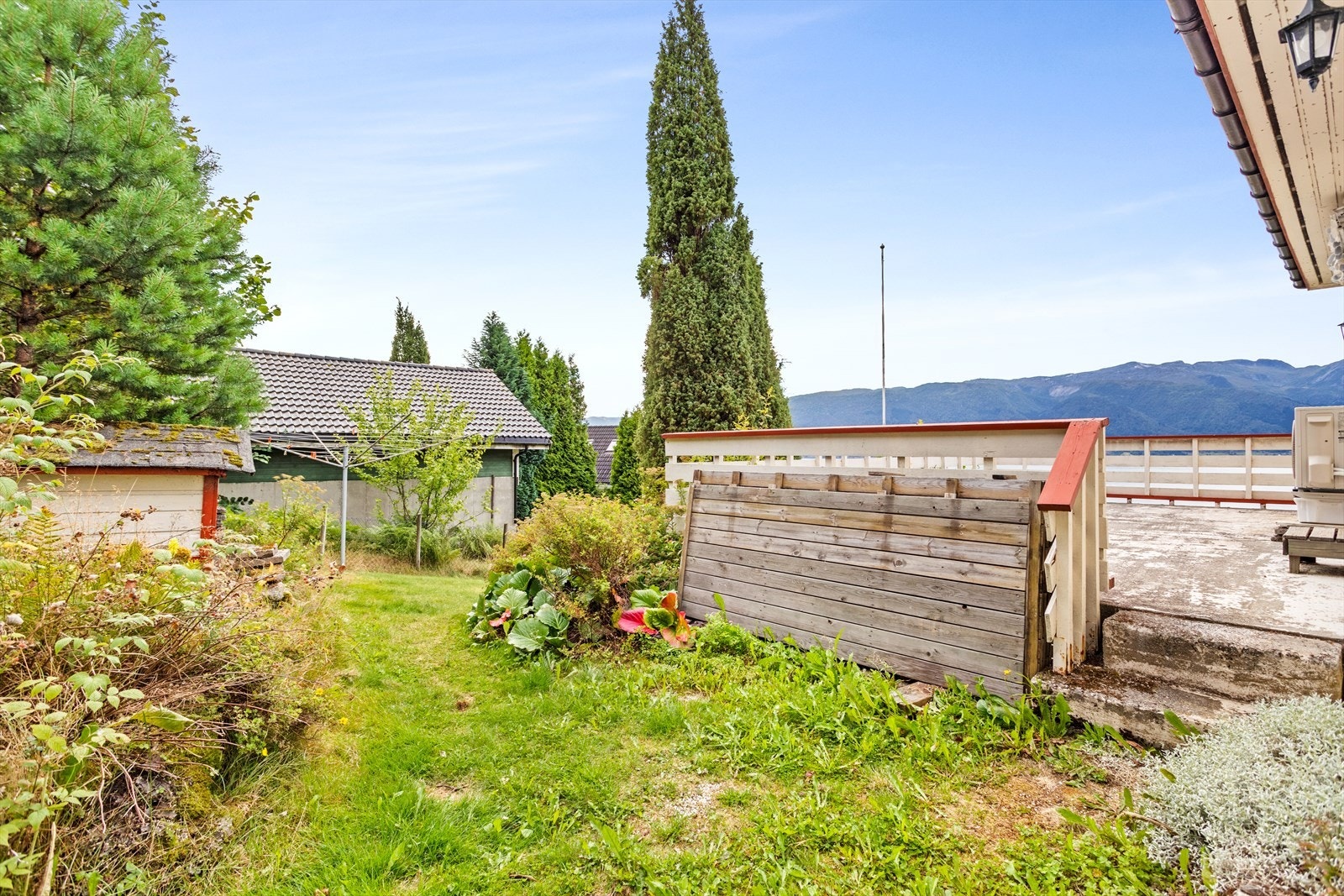 Tomta er opparbeidd med plan, pryd busker og uteplassar. Galleribilde