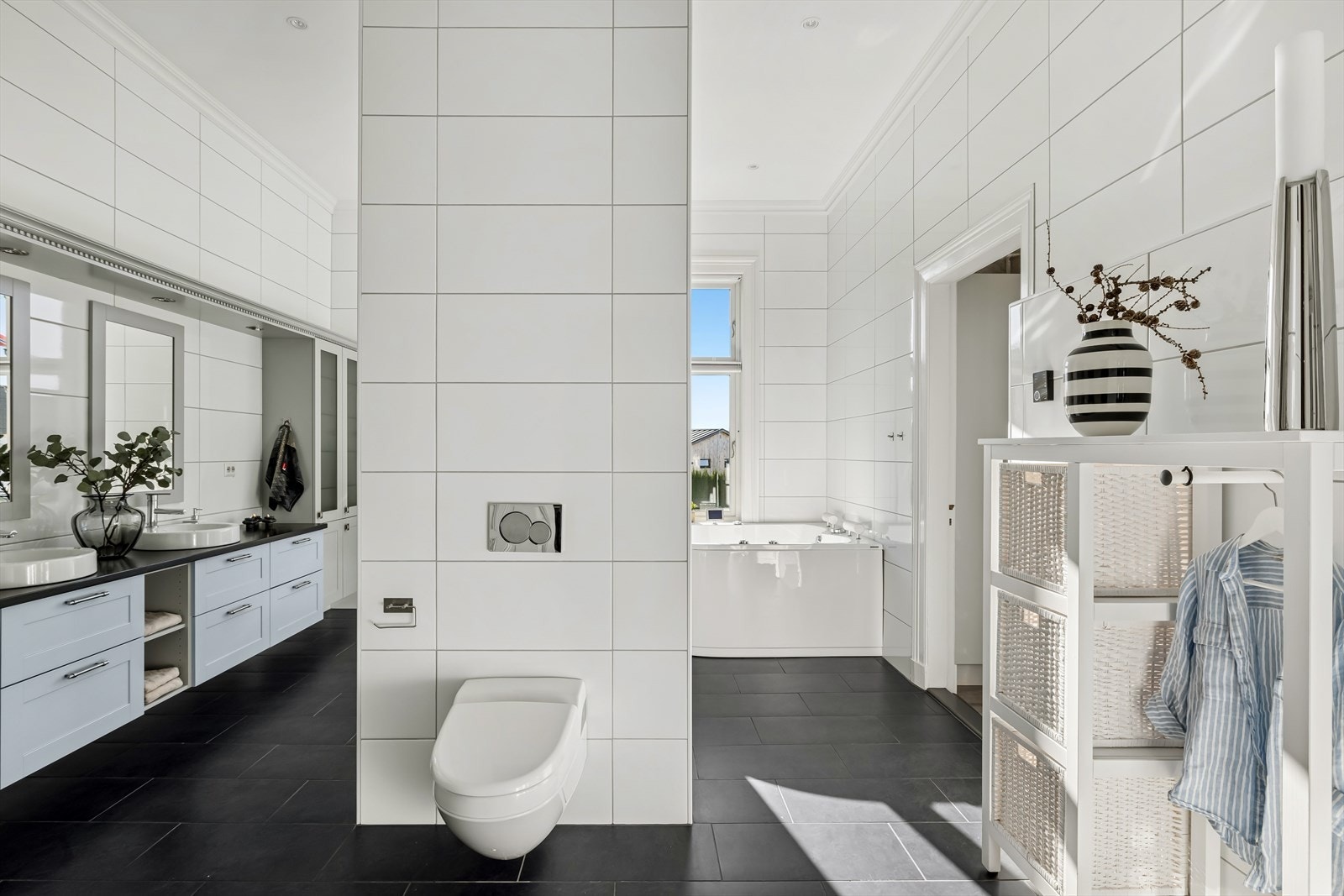 Innredning m/2 stk. servanter, speil m/belysning over, veggskap, dusjnisje m/glassvegger/dører, boblebadekar og vegghengt toalett. Galleribilde