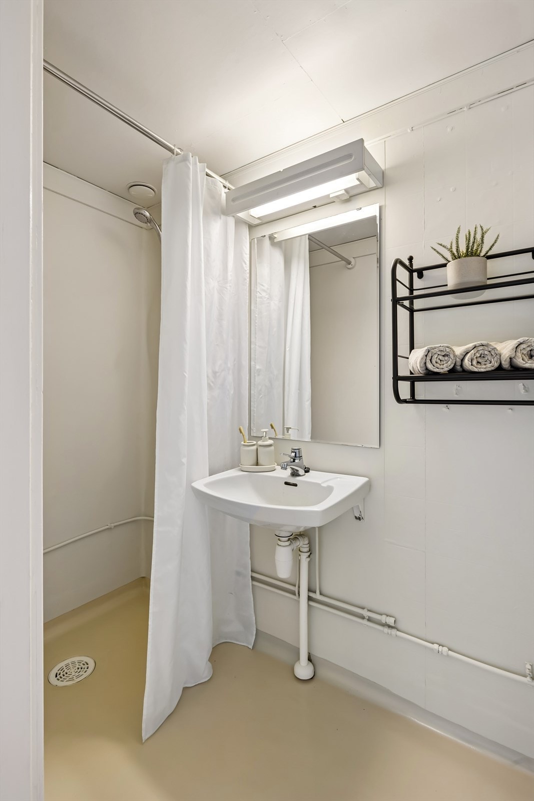 Dusjbad med enkel standard. Belegg på gulvet og plater på veggene. Separat toalettrom. Galleribilde