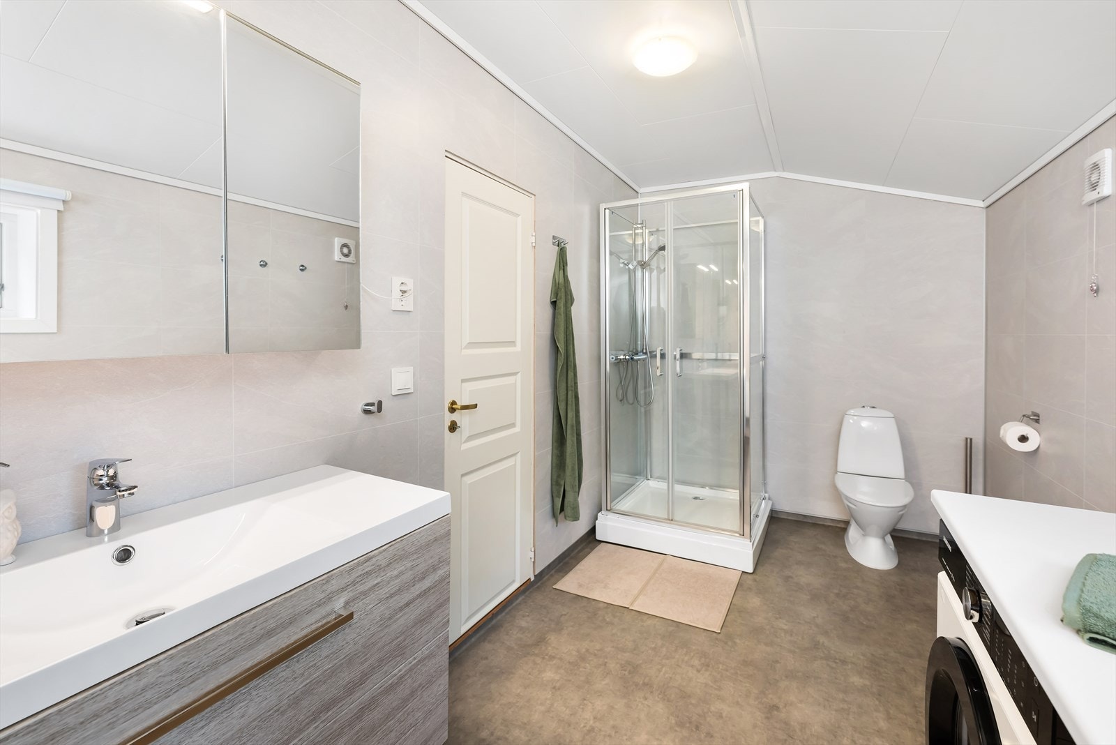 Det er baderomsplater på vegg og belegg på gulv. Galleribilde