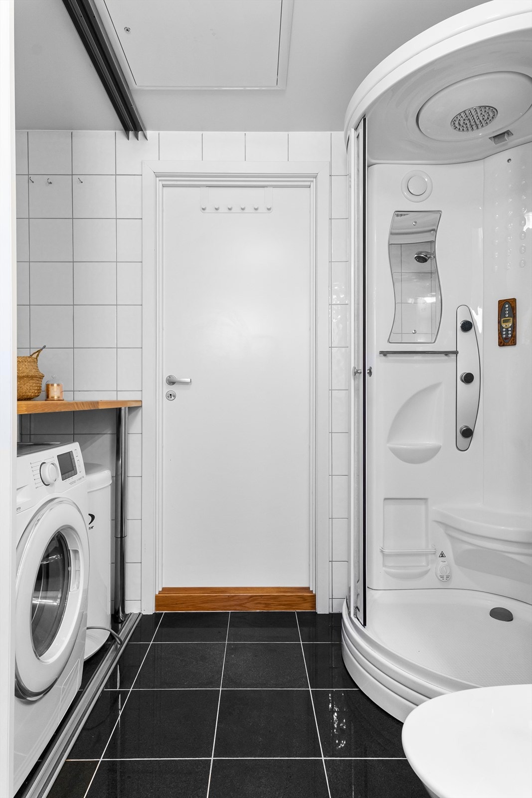 Bad kombinert vaskerom. Smart benkeløsning over maskiner. Helfliset med varme i gulv. Galleribilde