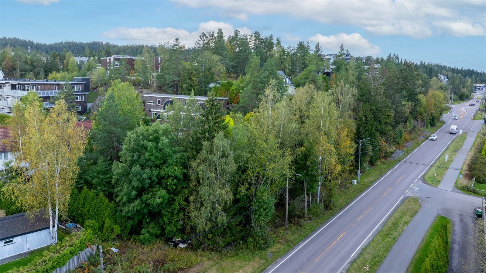 Tomten ligger med adkomst fra Nedre Rælingsveg, omgitt av grøntarealer og boligbebyggelse. Galleribilde