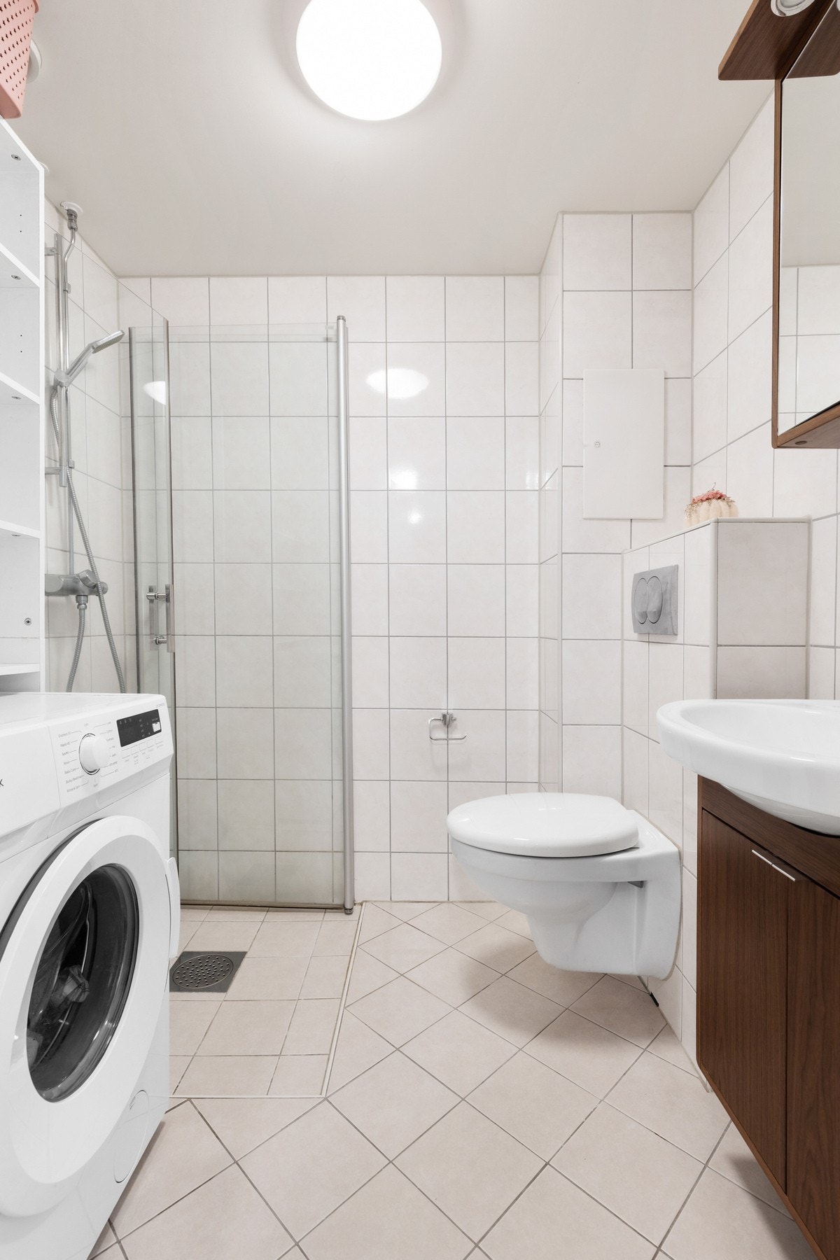 Badet består av dusjhjørne, vegghengt klosett, skap med under- og overskap, samt opplegg for vaskemaskin Galleribilde