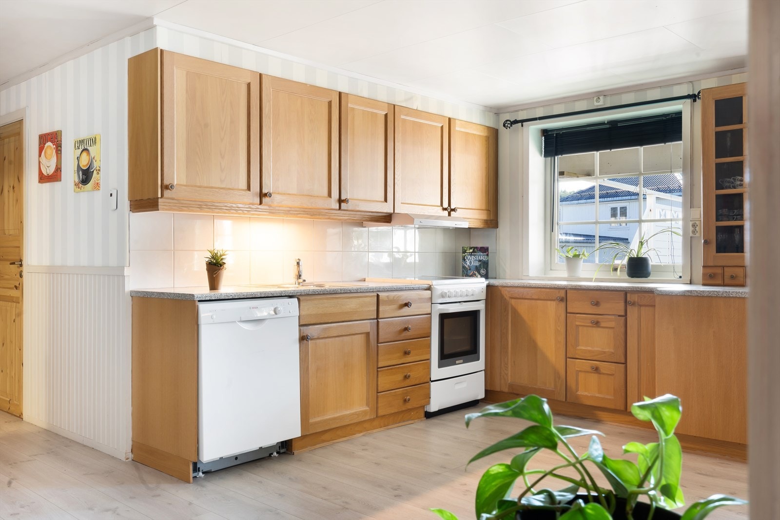 Kjøkkeninnredning med profilerte fronter, laminat benkeplate og fliser mellom over- og underskap. Galleribilde