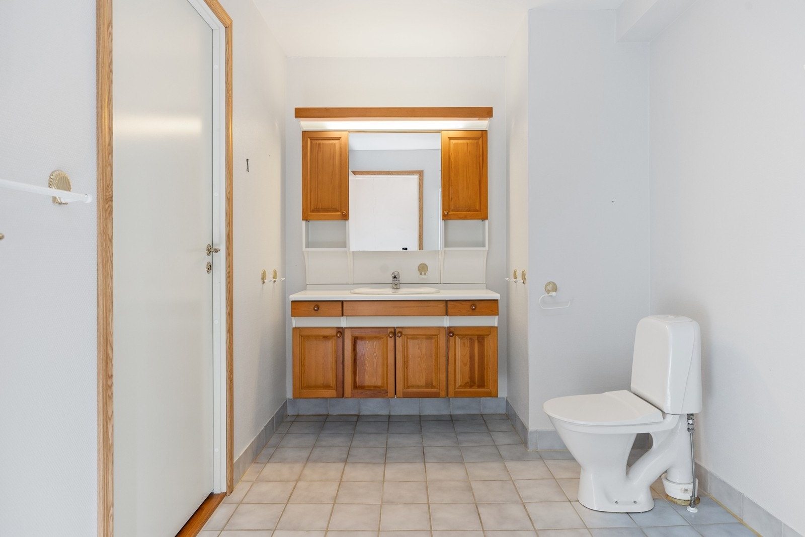 Baderommet har en standard fra byggetiden med fliser på gulv og malt glassfiberstrie på vegger Galleribilde