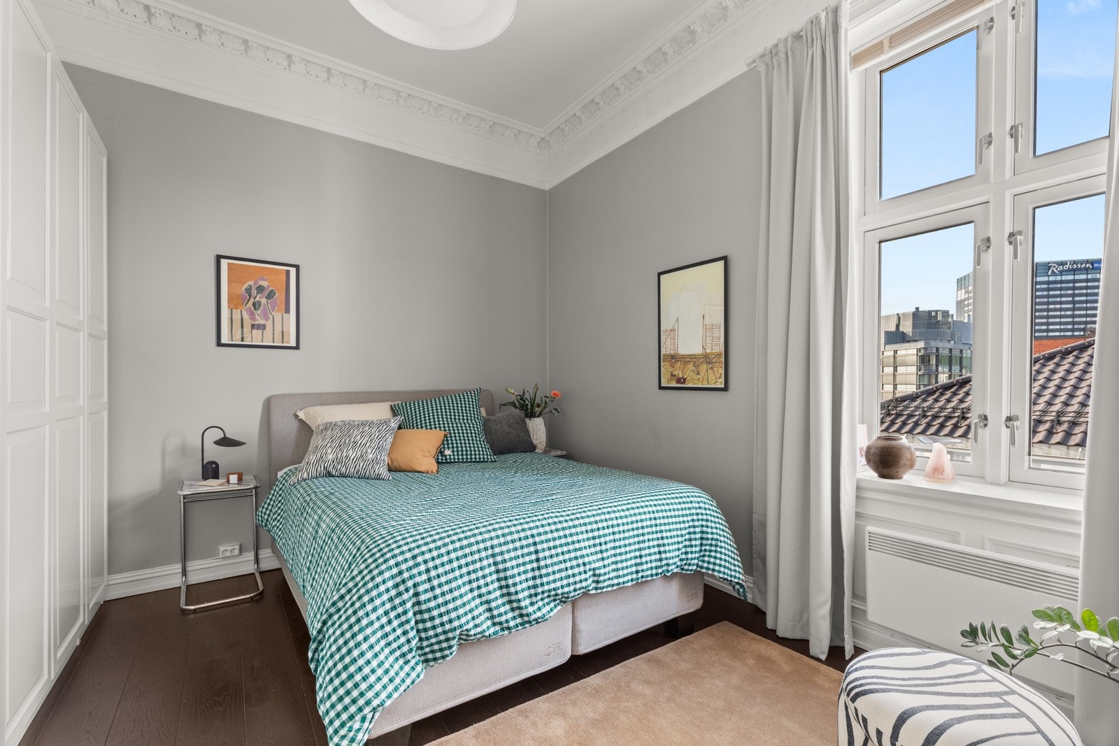 Lyst og delikat hovedsoverom. Garderobe med hvite profilerte fronter langs den ene langveggen. Galleribilde