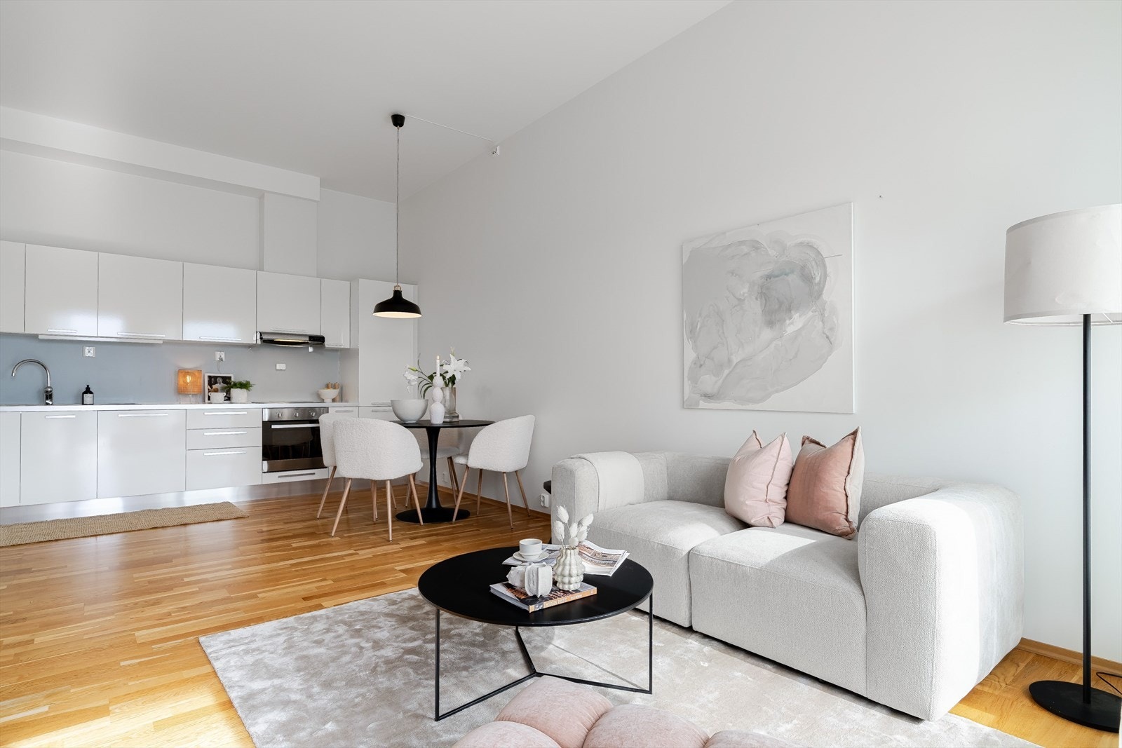 Åpen løsning mellom stue og kjøkken gir en romslig og sosial sone i boligens hjerte. Galleribilde