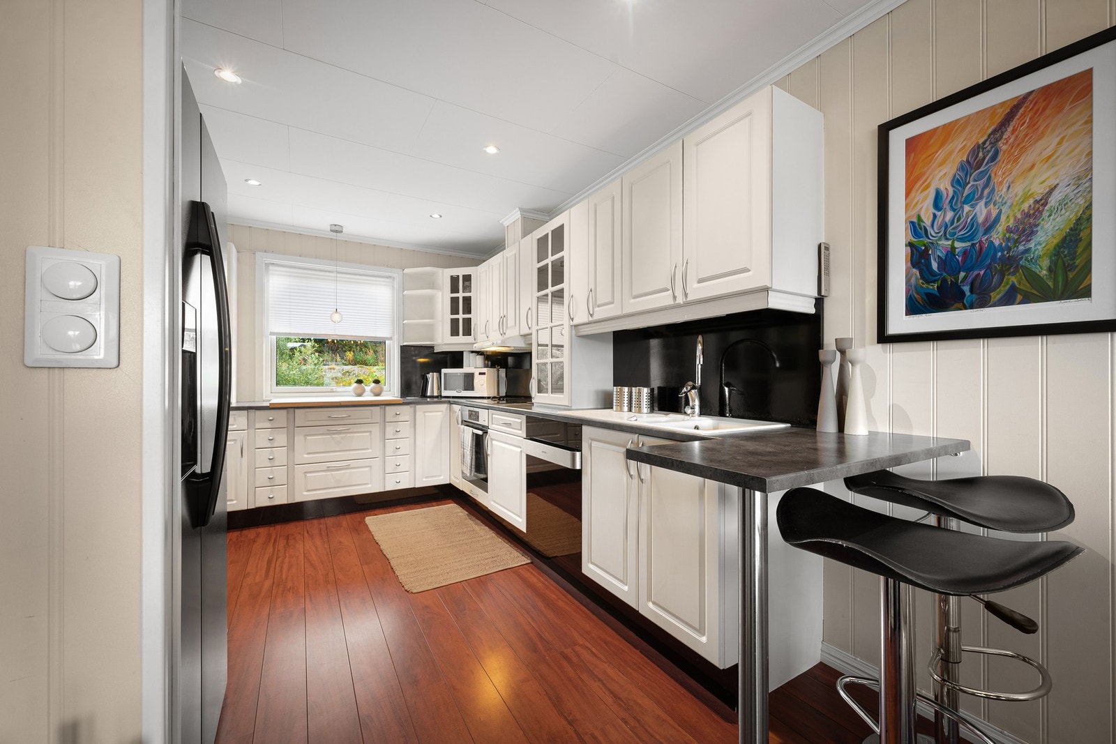 Barstoler ved kjøkkenbenken gjør rommet både sosialt og funksjonelt Galleribilde