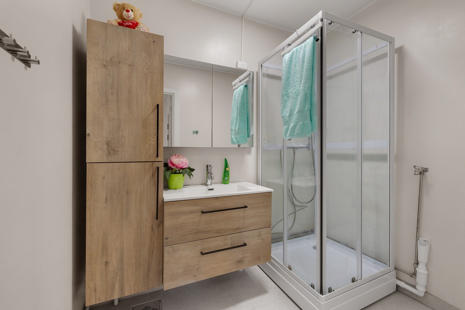 Delikat bad med flislagt gulv. Radiator på vegg. Galleribilde