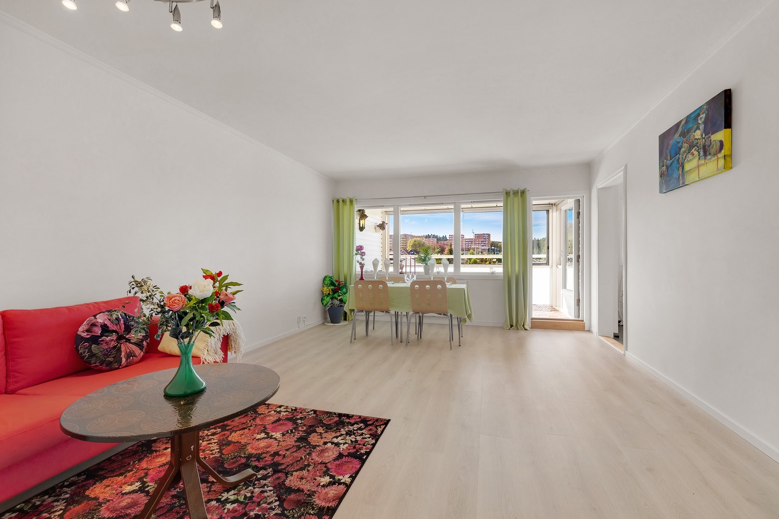 Lys og romslig stue med lyse flater og parkett på gulv. Galleribilde