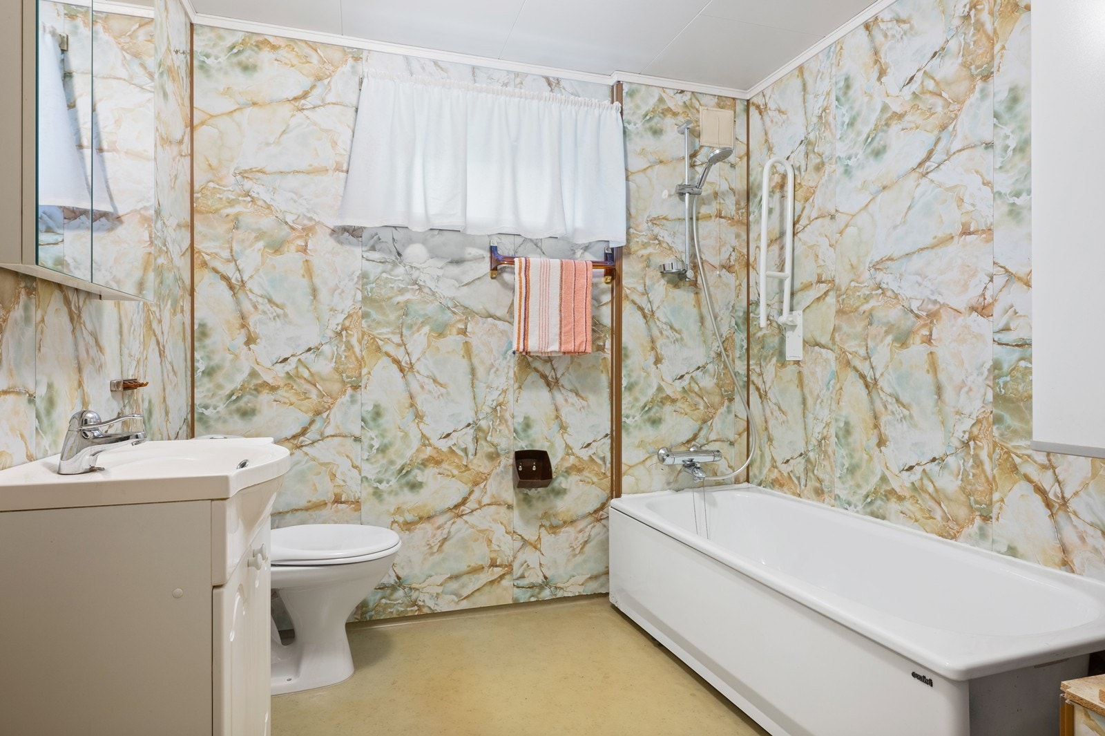 Badet har en eldre standard fra byggetiden, med belegg på gulvet og våtromsplater på veggene. Galleribilde