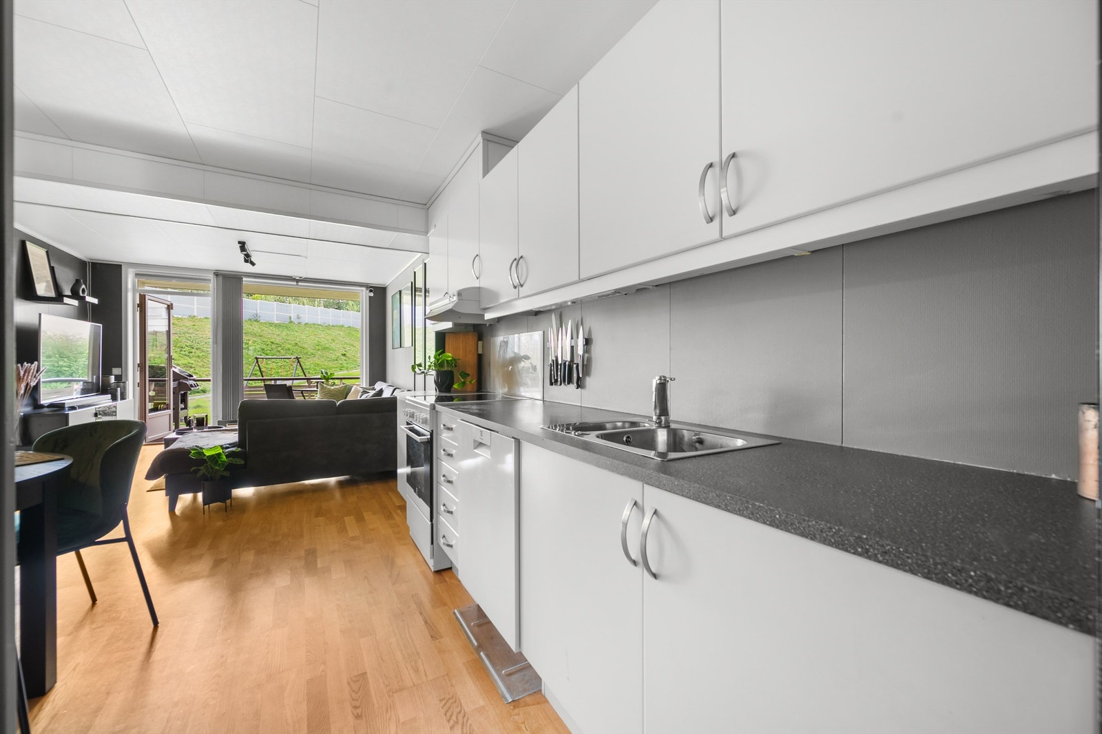 Kjøkkeninnredningen er av glatte fronter og laminat benkeplate med nedfelt vask- og skyllekum samt belysning over benkeplate. Galleribilde