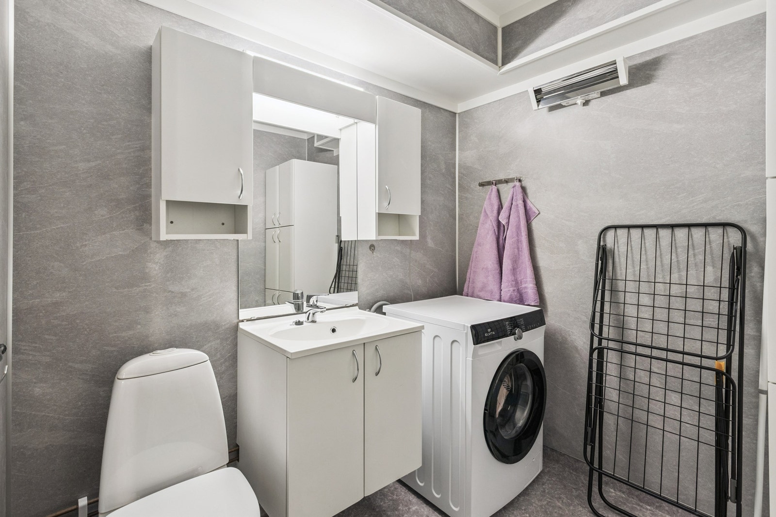 Her er det dusjkabinett, gulvmontert toalett og opplegg for vaskemaskin. Galleribilde