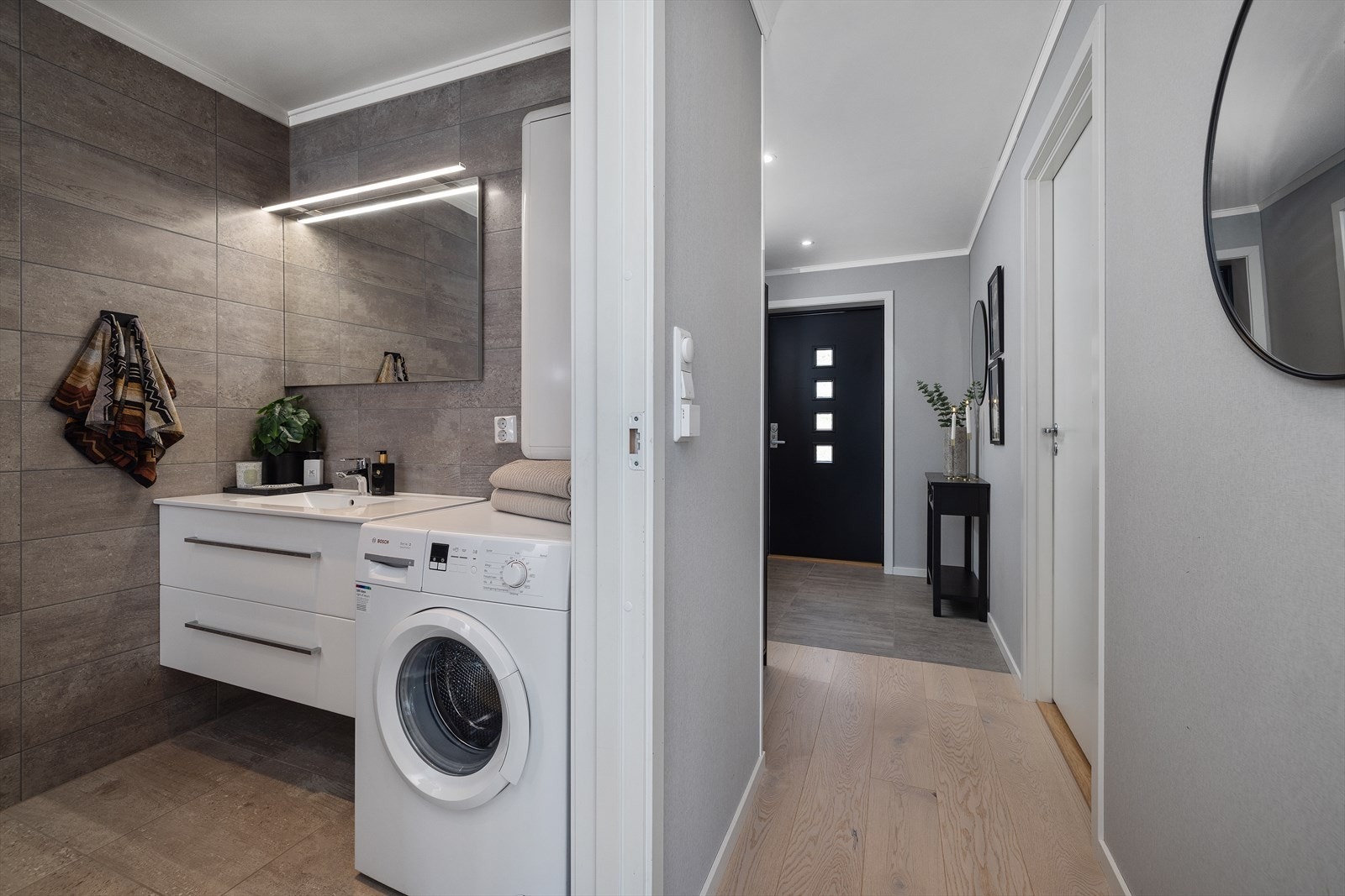 Moderne flislagt bad med opplegg for vaskemaskin. Varmekabler. Galleribilde