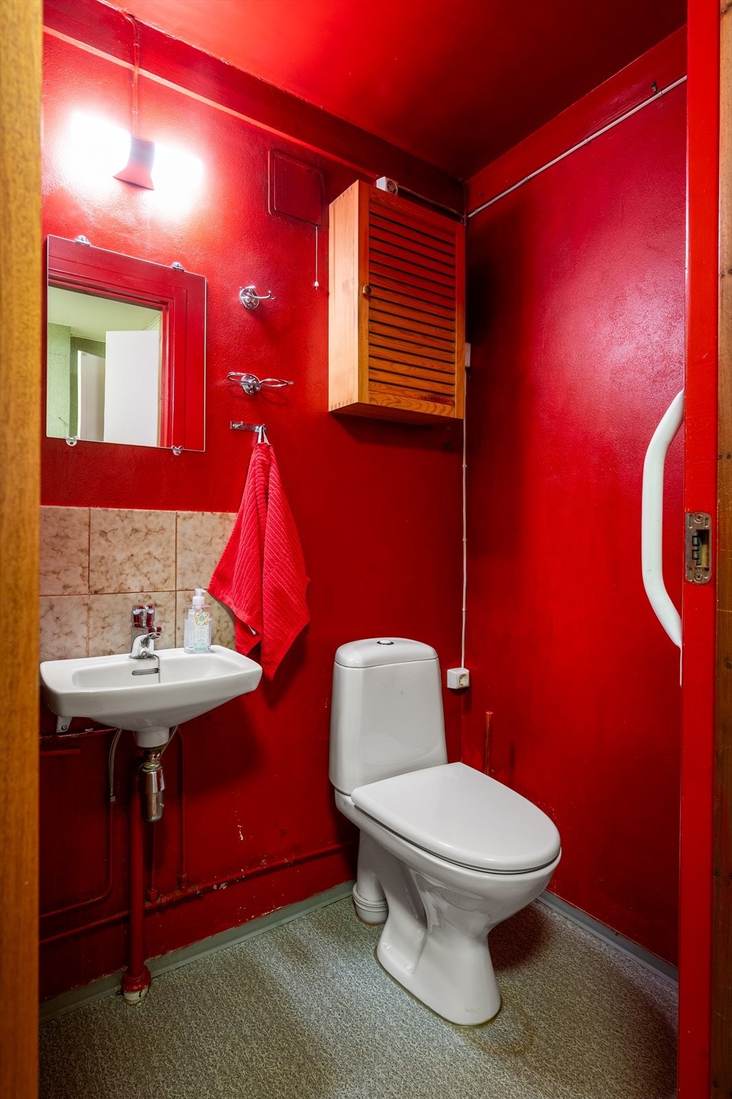 Romslig toalettrom med sprekt fargevalg, eldre innredning og wc. Galleribilde