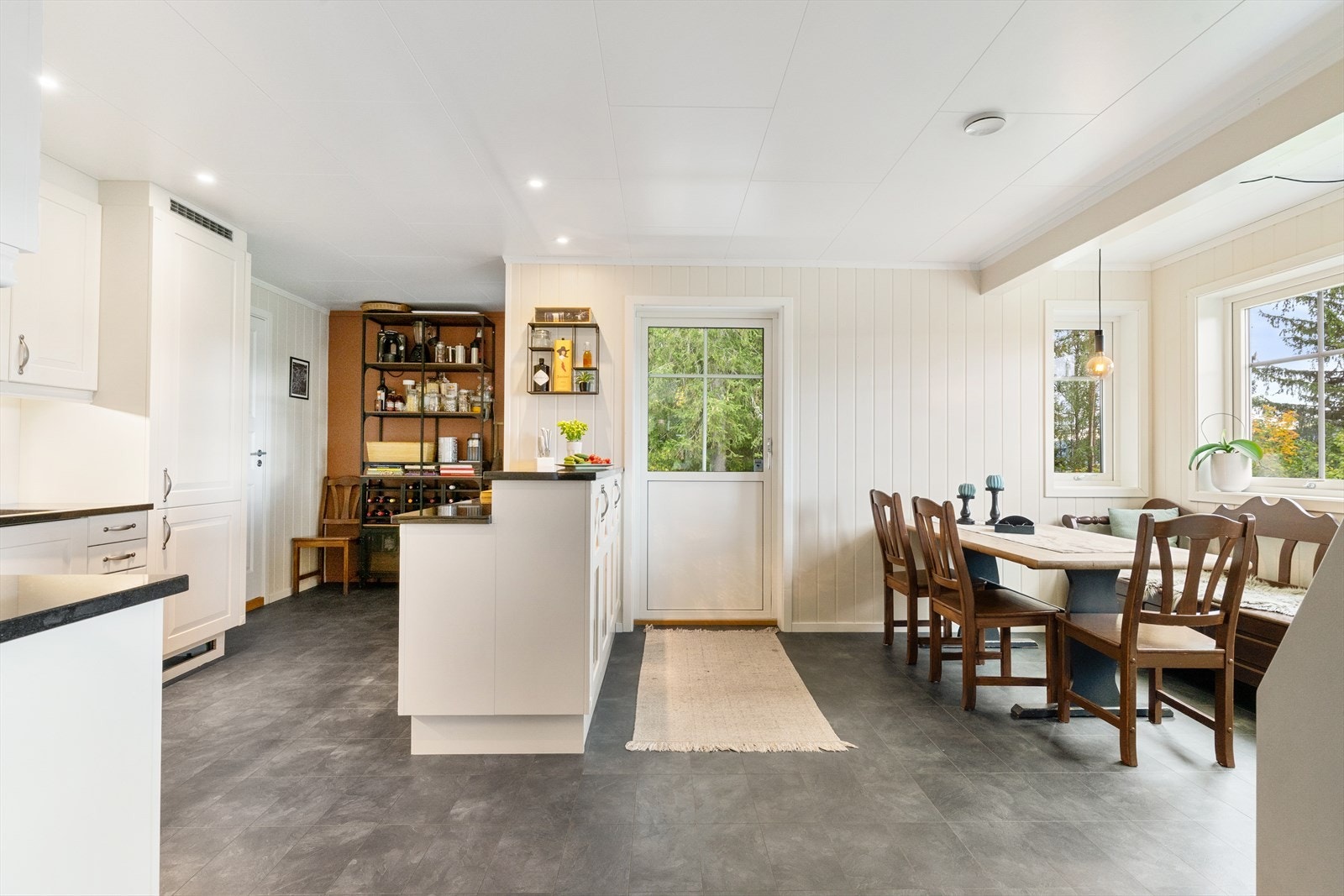 Eget kjøkkenrom med kjøkkenøy og spisekrok. Galleribilde