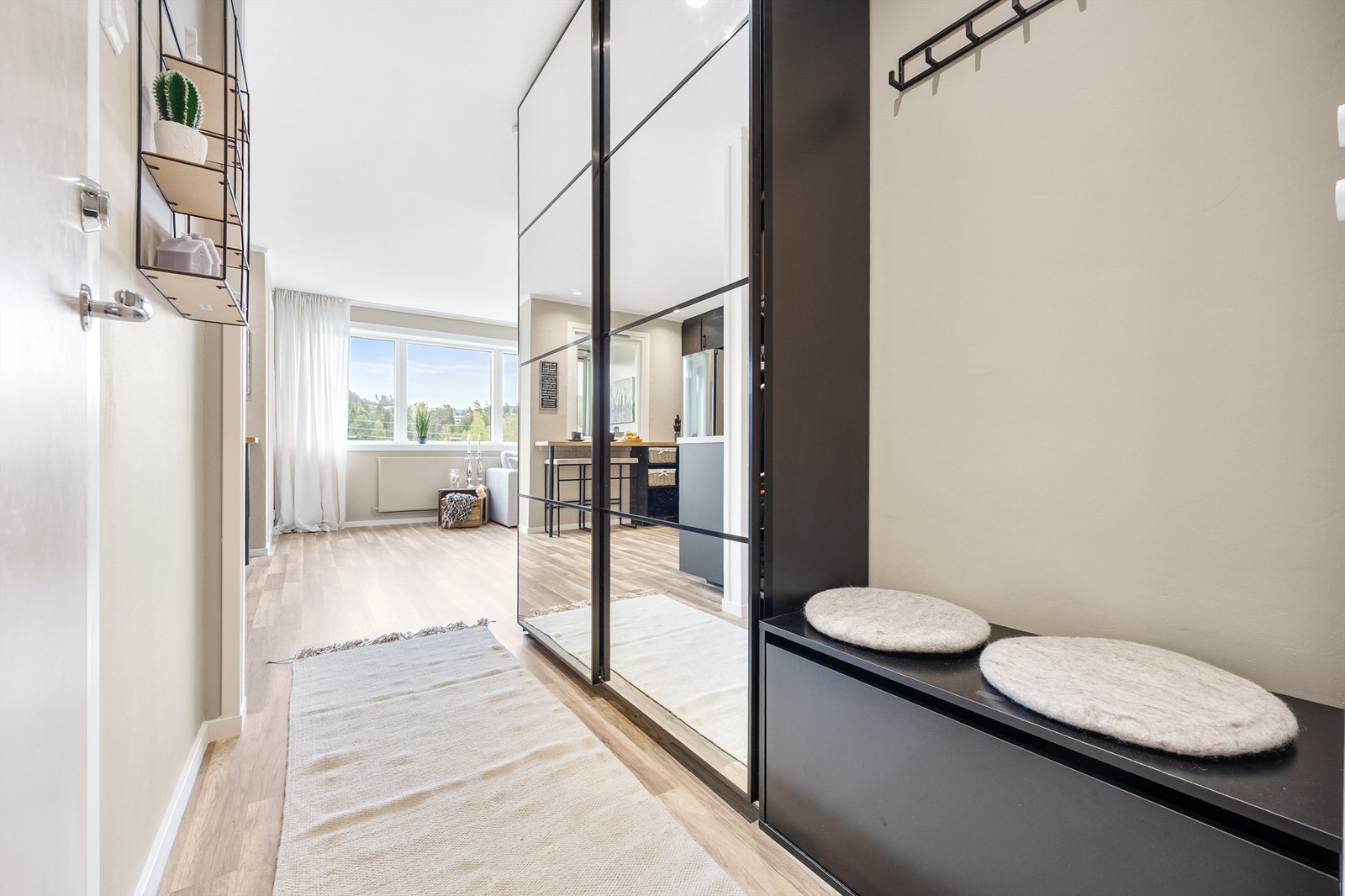 Lys og innbydende entre med praktisk garderobeløsning, speilfronter og sittebenk. God plass til oppbevaring og naturlig lysinnslipp fra vinduene i stuen. Galleribilde