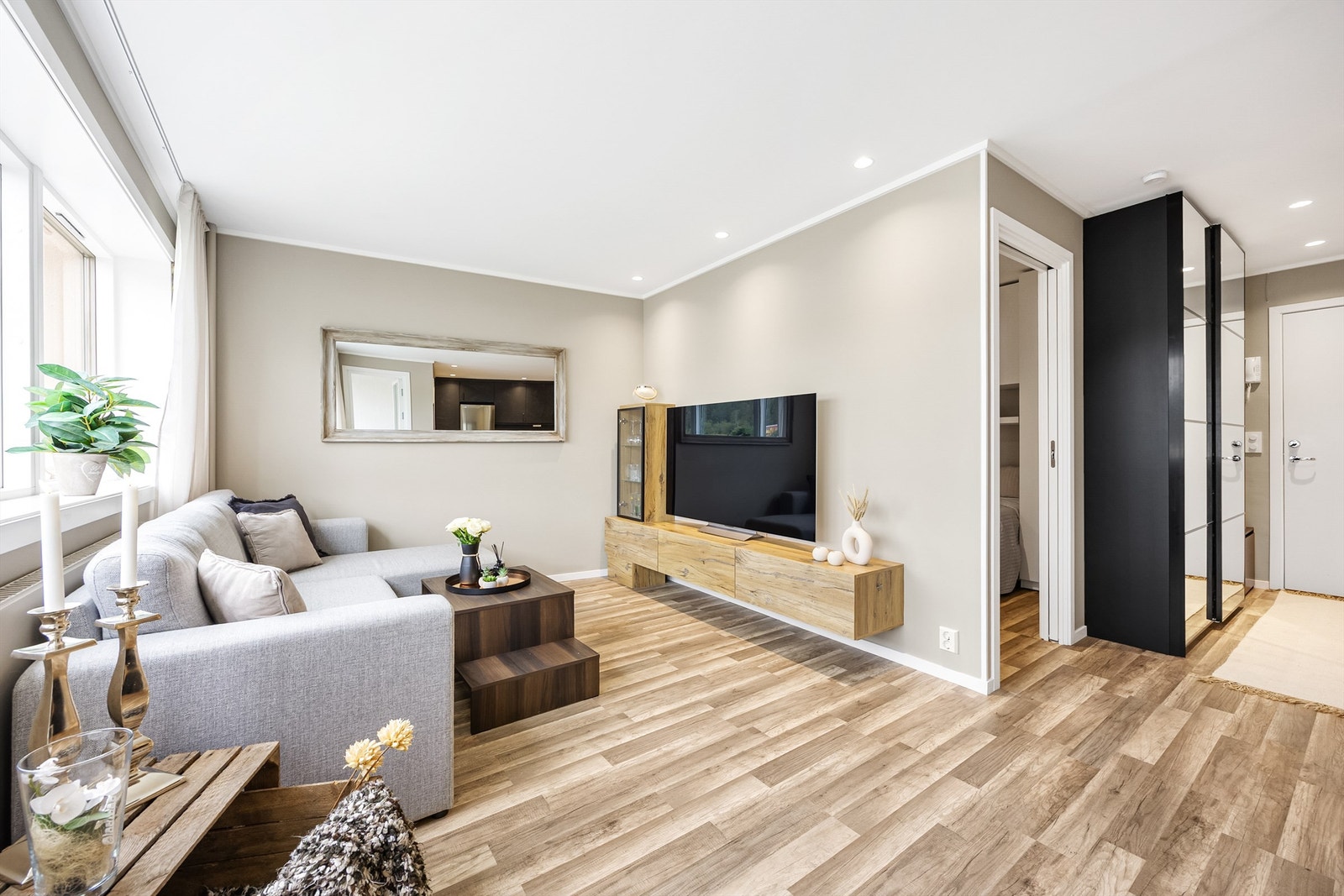 Lekker stue med dempende fargetoner og plassbygget mediemøbel i tre. Rommet har en lun og behagelig atmosfære, perfekt for avslapning og hygge. Fin gjennomgang mellom oppholdsrom, soverom og entre. Galleribilde