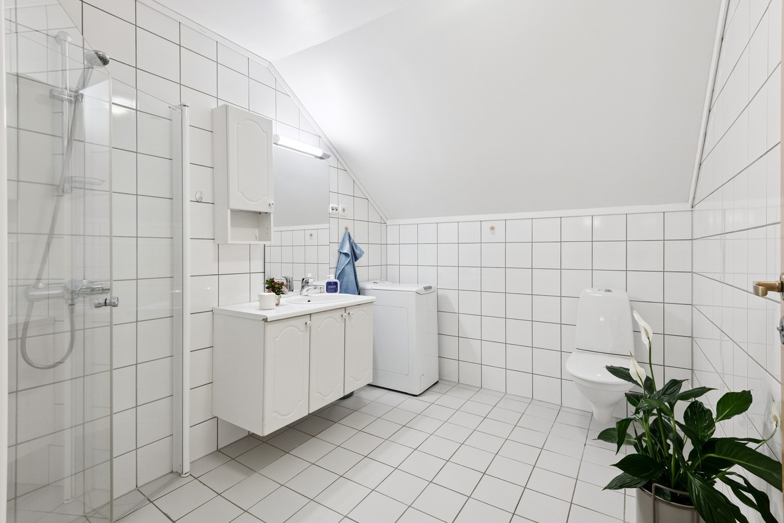 Flislagt bad med gulvvarme, dusjhjørne, innredning, vegghengt toalett. I tillegg er det opplegg for vaskemaskin på badet. Galleribilde