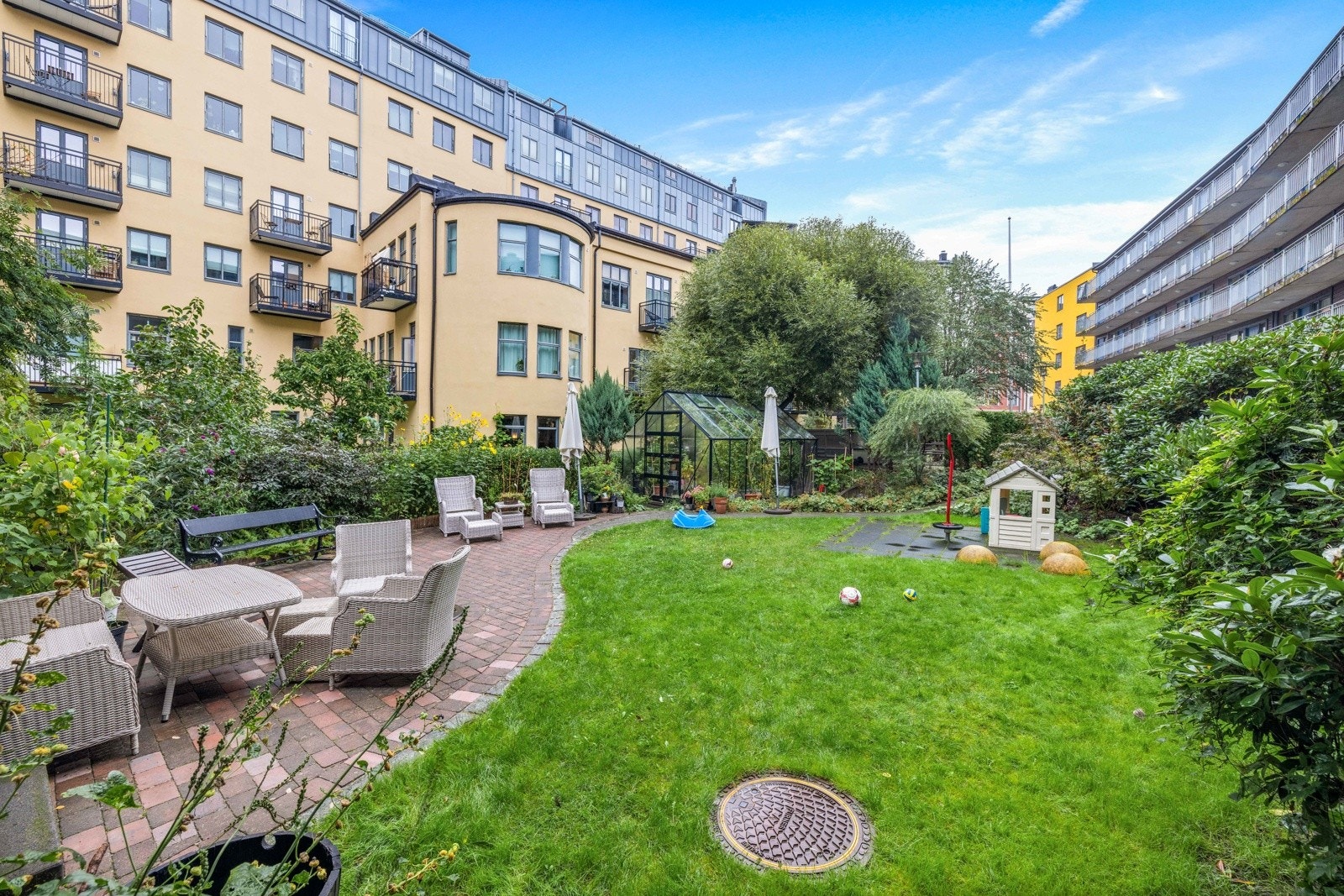 Beboerne i borettslaget har tilgang til en flott og frodig bakgård med flere sittegrupper, drivhus og lekearealer. Galleribilde