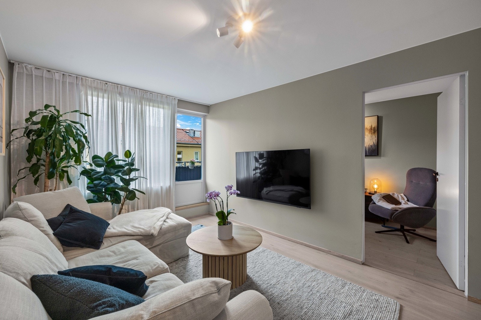 Det er takhøye gardinskinner, store vinduer og dør ut til balkongen. Galleribilde