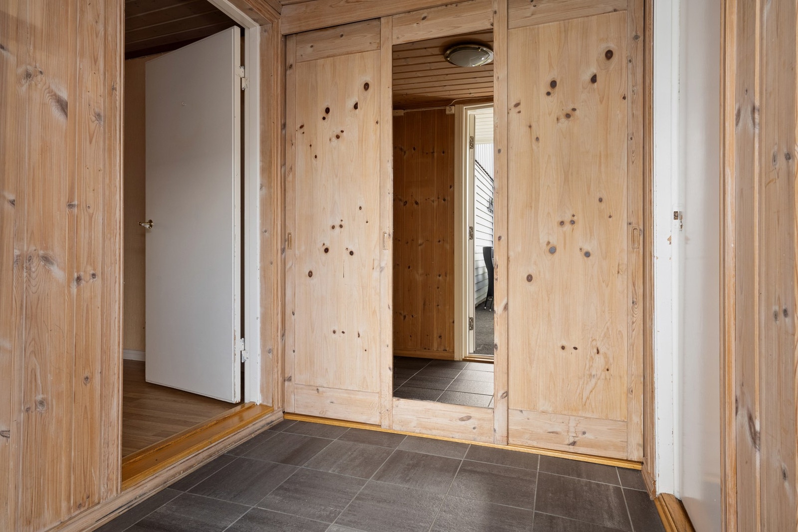 Det er et romslig inngangsparti med skyvedørsgarderobe Galleribilde