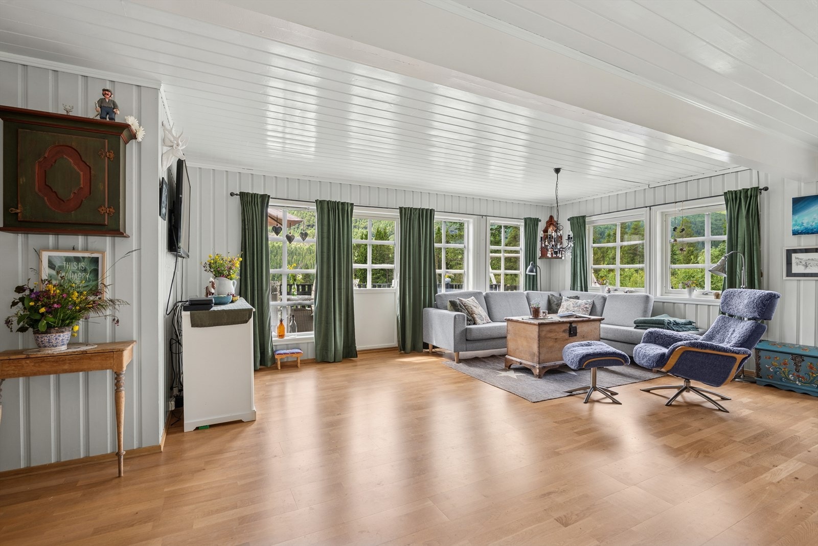 Inne finner du en romslig stue med åpen planløsning mot kjøkken og spisestue, hvor store vindusflater slipper inn rikelig med naturlig lys. Galleribilde