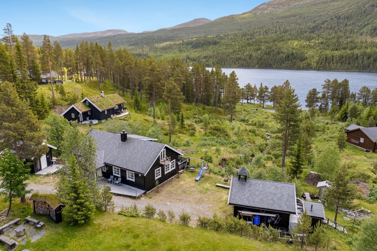 Her får du en hytte med innholdsrik tomt som ligger høyt og fritt med nydelig utsikt mot vannet Galleribilde