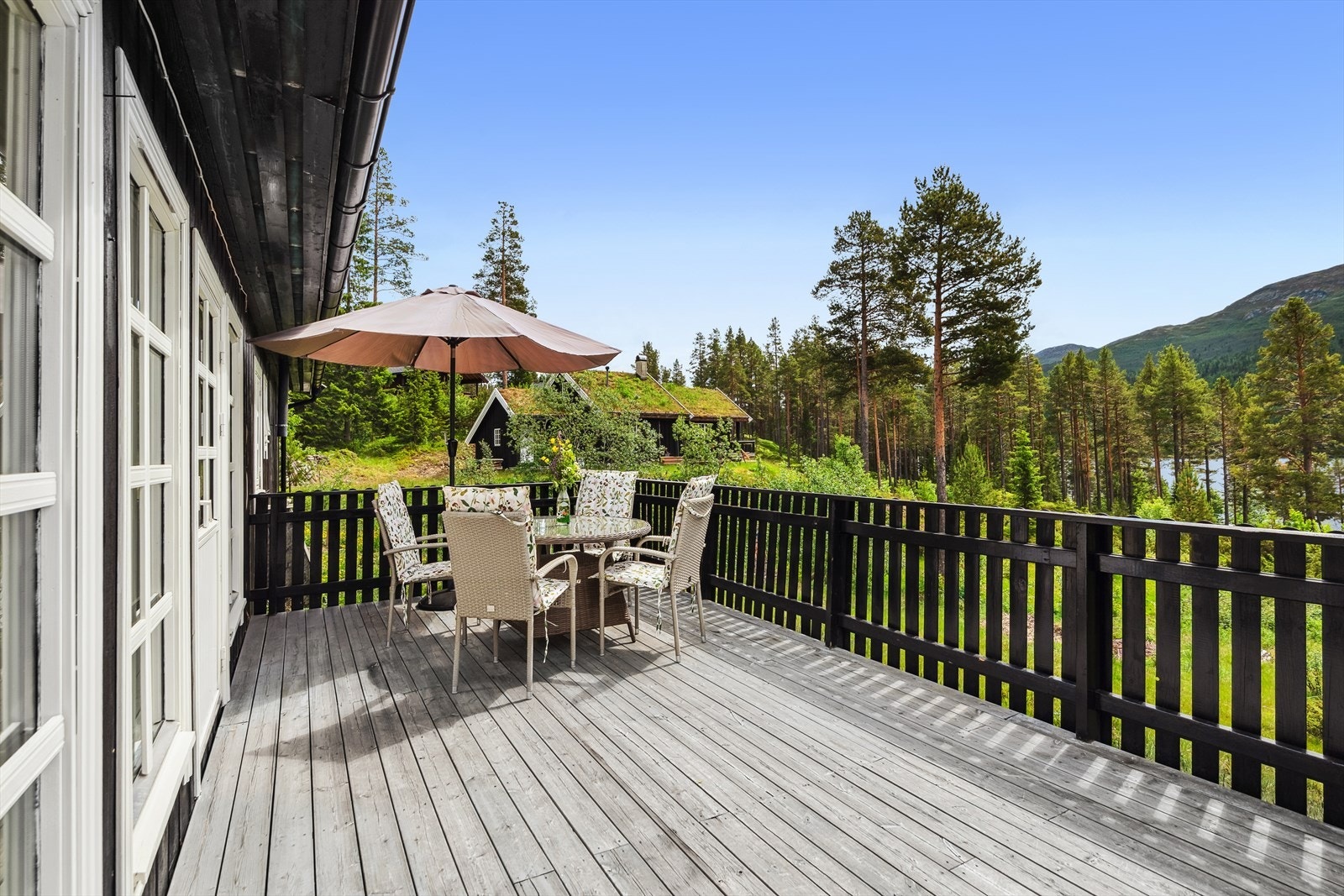 Solrik terrasse med flott utsikt, perfekt for avslapning og sosiale sammenkomster i naturskjønne omgivelser. Terrassen er sørvestvendt. Galleribilde