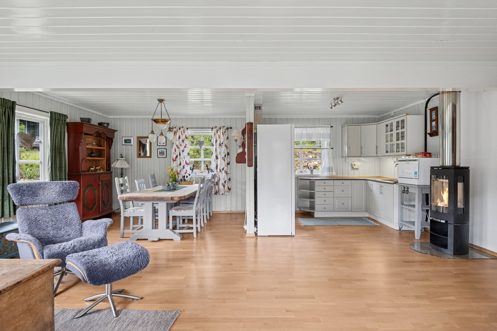 Åpen løsning mellom kjøkken og spisestue med god plass til et stort bord som kan romme hele familien. I kjøkkenområdet finnes også en flott nyere peis, som skaper ekstra varme og hygge på kjølige kvelder. Galleribilde