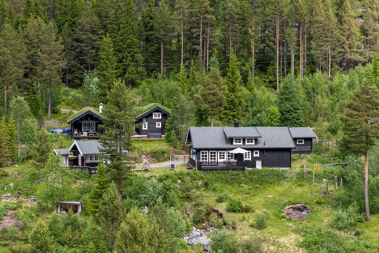 Her får du en hytte med innholdsrik tomt som ligger høyt og fritt med nydelig utsikt mot vannet Galleribilde