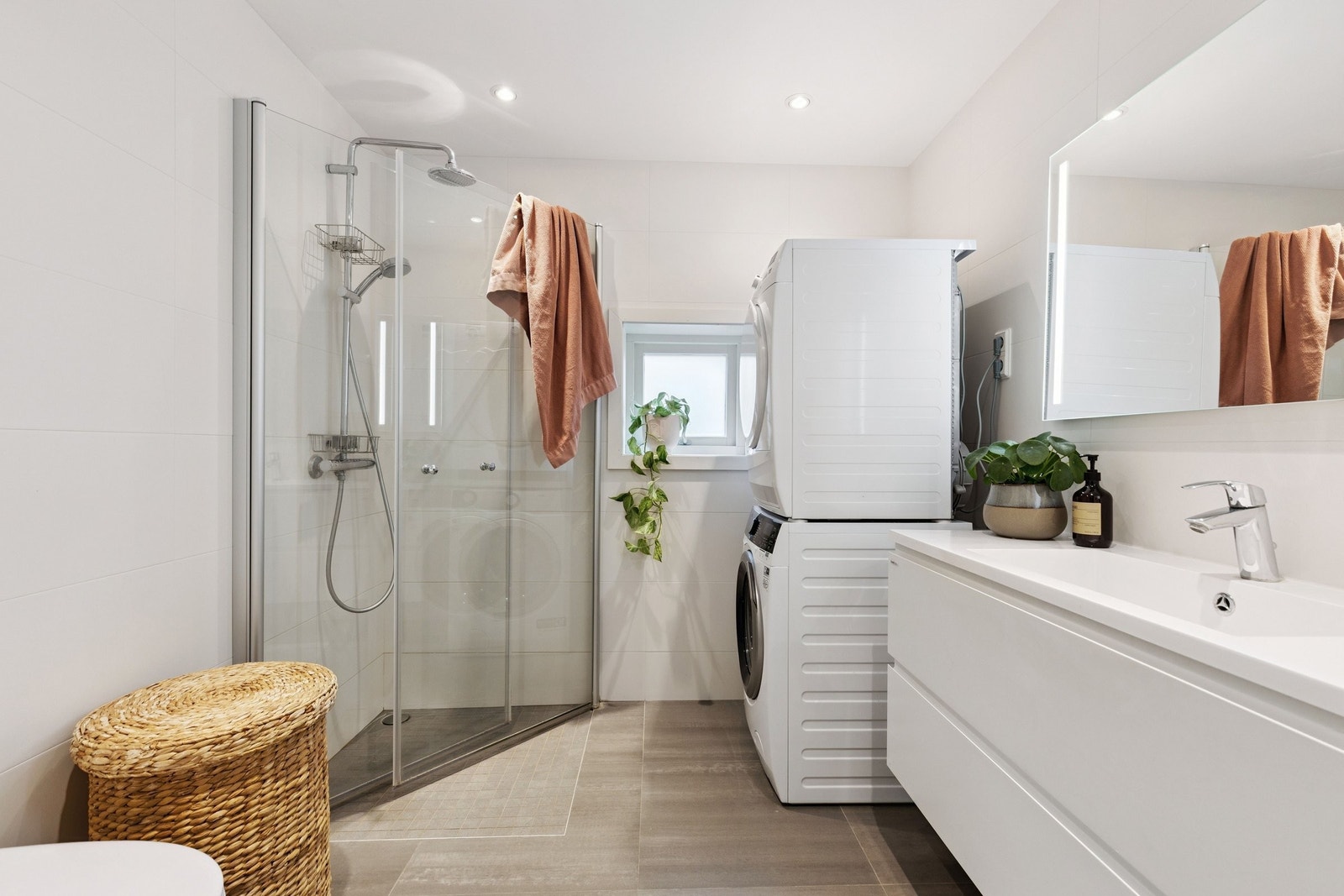 Praktisk bad i første etasje med vegghengt toalett, servantinnredning og dusjhjørne
med glassdører. Opplegg for vaskemaskin og tørketrommel. Galleribilde