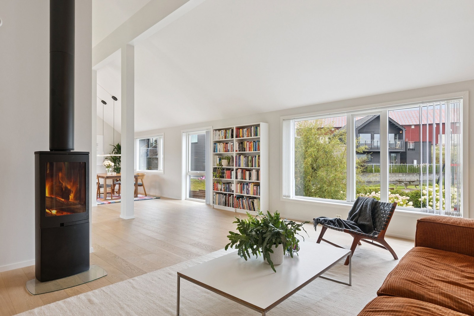 Vedfyring i stuen med peisovn med glassdør. Det store stuevinduet har også elektrisk utvendig screens. Galleribilde